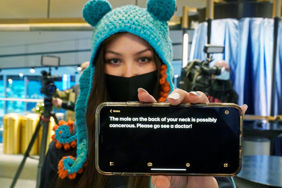 Seattle Kraken fan Nadia Popovici is showing the text of a message she showed to Canucks assistant equipment manager Brian “Red” Hamilton on Oct. 23, as she sat behind the Canucks’ bench during the Kraken’s home-opener hockey game.  (Ted S. Warren)