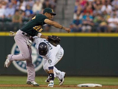 Seattle’s Jose Lopez unsuccessfully attempts to break up the double-play relay throw by Oakland’s Bobby Crosby in the second inning.  (Associated Press / The Spokesman-Review)