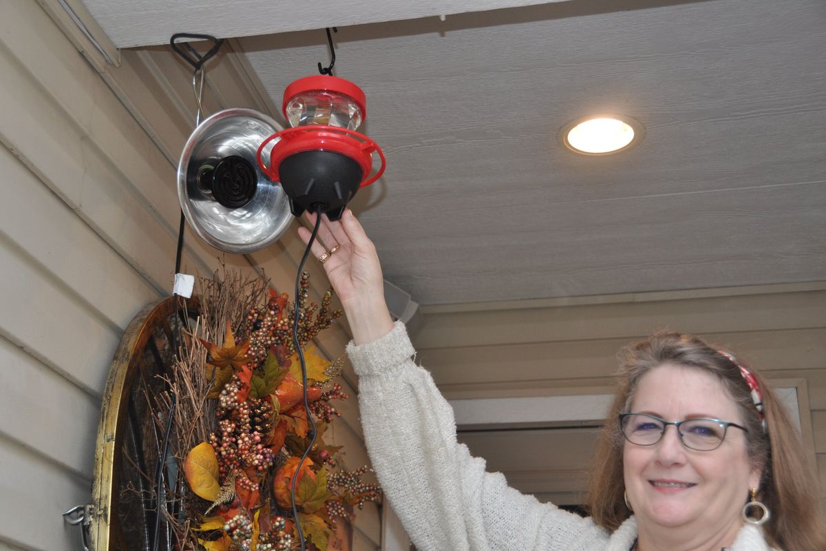 Liberty Lake resident Shelly Horner shows off her commercial heated hummingbird feeder that keeps the syrup from freezing. Horner backed the feeder with a 7-watt reptile heating lamp to keep a recent visitor, an Anna’s hummingbird, warm during the cold weather.  (Pat Munts/For The Spokesman-Review)