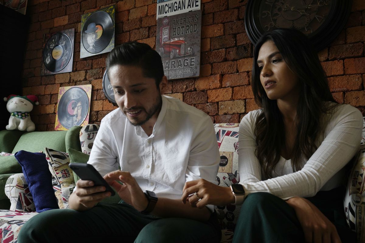 Doctor David Vallejo and his fiancee Doctor Mavelin Bonilla rest at home in Quito, Ecuador, Wednesday, June 9, 2021. Doctor Vallejo and Doctor Bonilla suspended their wedding in order to tend to COVID-19 patients and in the process, Vallejo got sick himself with the disease, ending up in an ICU for several days.  (Dolores Ochoa)