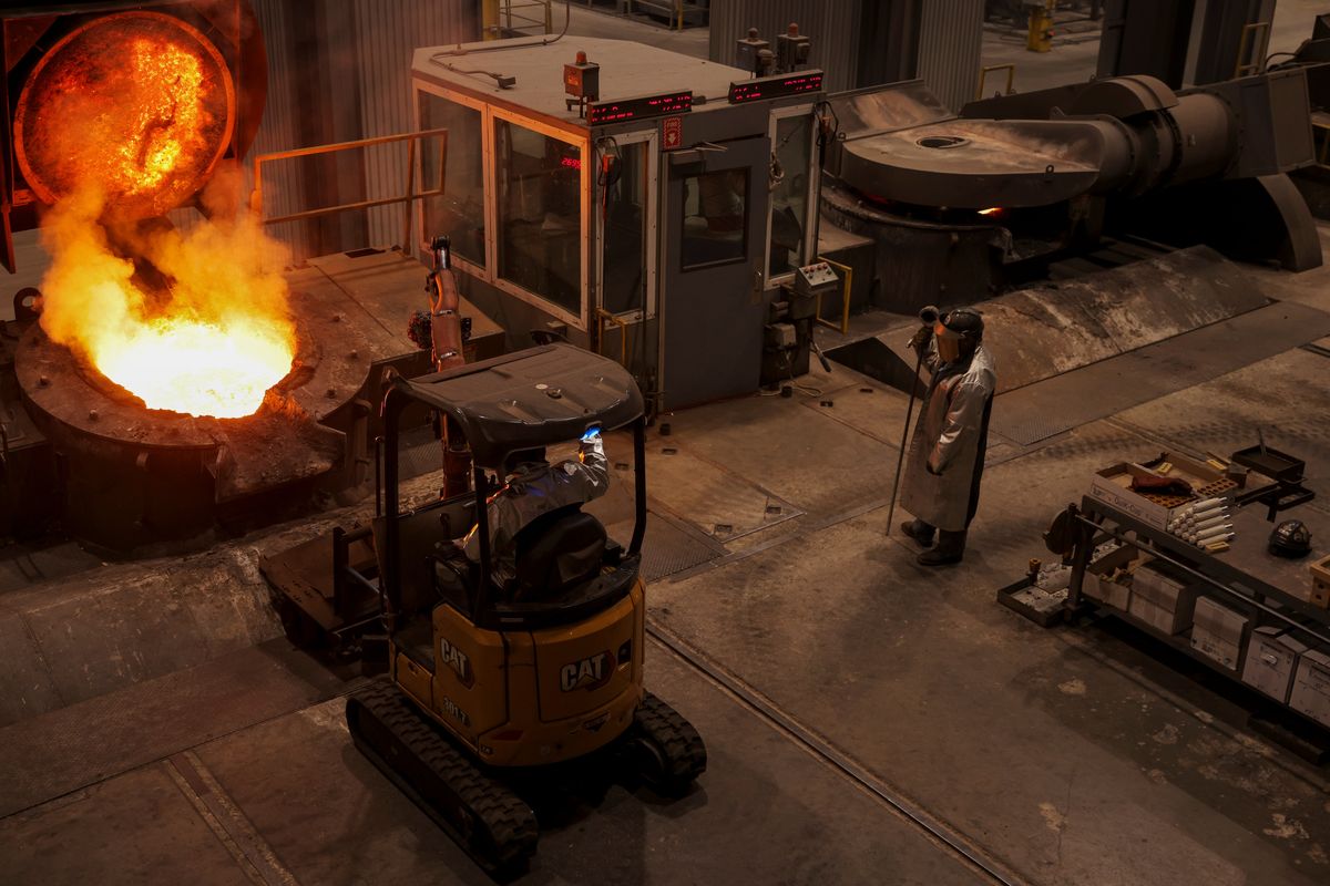 Employees remove impurities from molten iron as it is heated at Charlotte Pipe and Foundry on May 22 in Charlotte, N.C.  (TRAVIS DOVE)