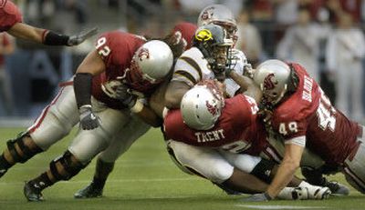 
Grambling quarterback Bruce Eugene is buried several Cougars, including  Fevaea'i Ahmu (92),  Greg Trent and  Steve Dildine (49).
 (Christopher Anderson/ / The Spokesman-Review)