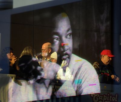 An image of  the Rev. Martin Luther King Jr. from the marquee is reflected onto the glass of the INB Performing Arts Center,  where more than  1,000 people gathered  before the  Unity March through downtown Spokane on Monday.  (J. BART RAYNIAK)