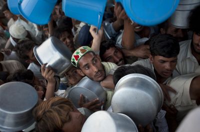 Displaced men and boys struggle to get their daily ration during a food distribution at the Chota Lahore refugee camp in northwest Pakistan on Saturday.  (Associated Press / The Spokesman-Review)