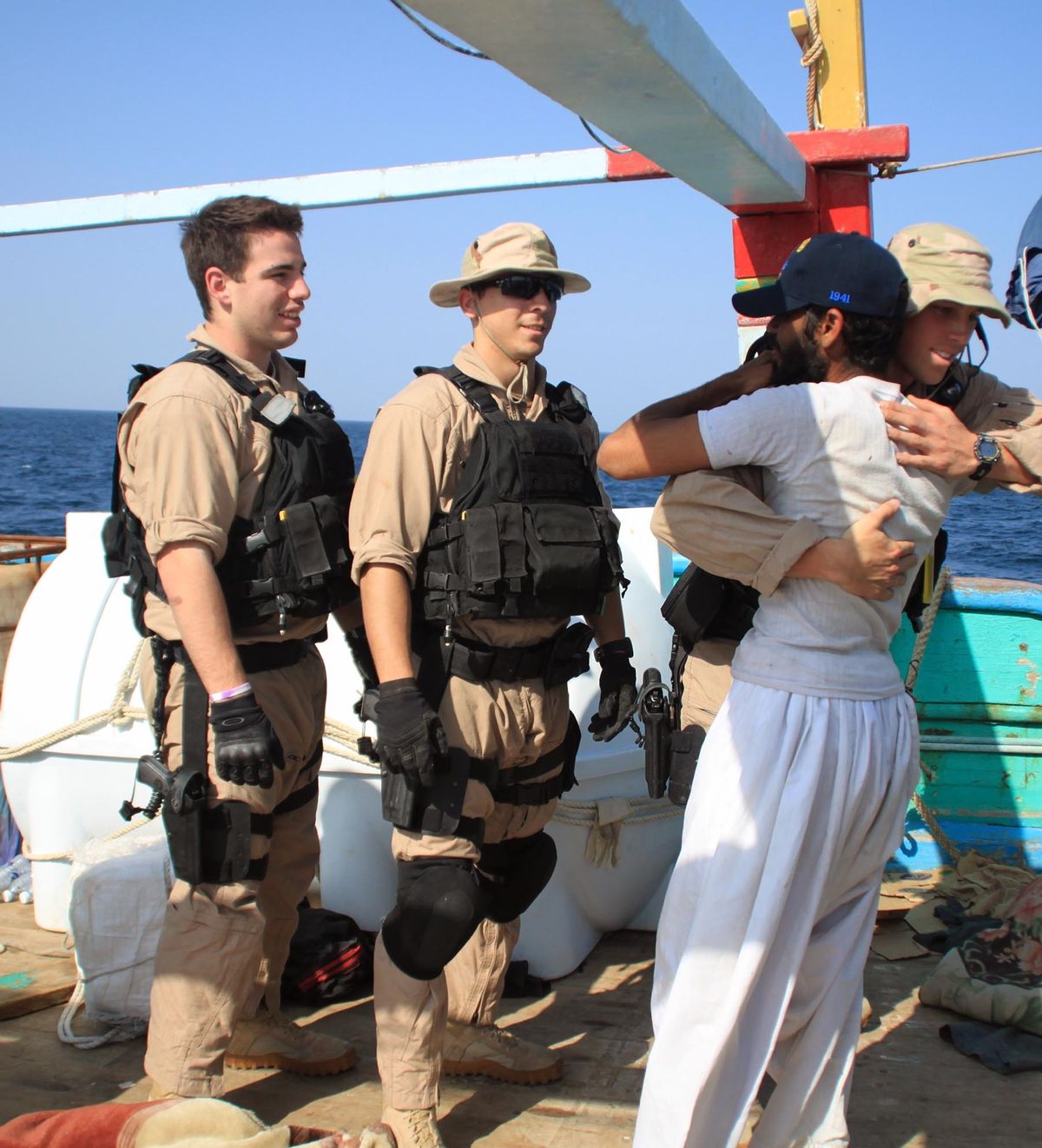Navy sailors assigned to the guided-missile destroyer USS Kidd greet a crew member of the Iranian fishing vessel the Al Molai on Friday in the Arabian Sea. (Associated Press)