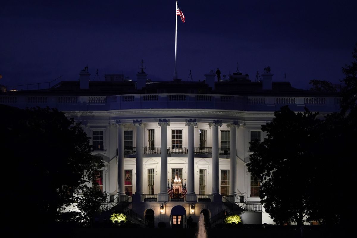 FILE - In this Oct. 5, 2020, file photo an American flag files atop the White House after President Donald Trump arrived from Walter Reed National Military Medical Center via Marine One in Washington.  (J. Scott Applewhite)