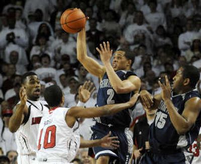 
Georgetown's Johathan Wallace, center, tries to save the ball over Louisville players Terrence Williams, left, and Edgar Sosa. Associated Press
 (Associated Press / The Spokesman-Review)