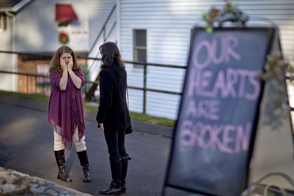 Shop owners Tamara Doherty, left, and Jackie Gaudet, right, meet outside their stores for the first time since being neighbors, just down the road from Sandy Hook Elementary School, Saturday, Dec. 15, 2012, in Newtown, Conn. The massacre of 26 children and adults at Sandy Hook Elementary school elicited horror and soul-searching around the world even as it raised more basic questions about why the gunman, 20-year-old Adam Lanza, would have been driven to such a crime and how he chose his victims. (David Goldman / Associated Press)