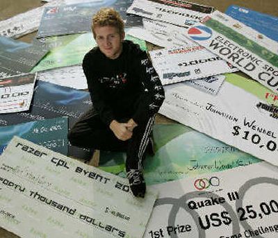 
Jonathan Wendel, AKA Fatality, sits among presentation checks from some of the video gaming tournaments he has won.  
 (The Spokesman-Review)