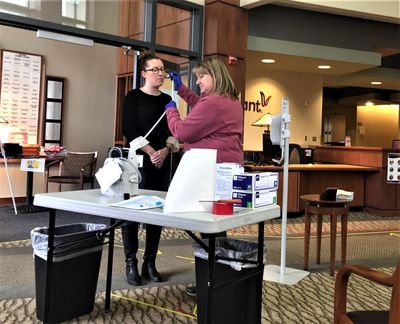 Vitalant blood donor care manager Sarah Buckley, left, has her temperature checked by courier Teresa Deach as part of preventative safety measures. Staff members have their temperature checked upon arrival in the morning and at midday. (Sherry Kenady / For The Spokesman-Review)