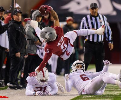 Washington State wide receiver Lincoln Victor flies over Stanford’s Aaron Morris, left, and Collin Wright on Saturday at Gesa Field.  (Geoff Crimmins/For The Spokesman-Review)