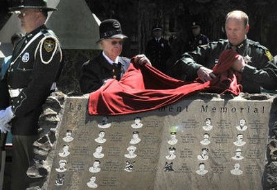 
Glen Whiteley, curator and president of the Spokane Law Enforcement Museum, left, and Spokane County Sheriff Ozzie Knezovich pull the cover off the  memorial.
 (The Spokesman-Review)