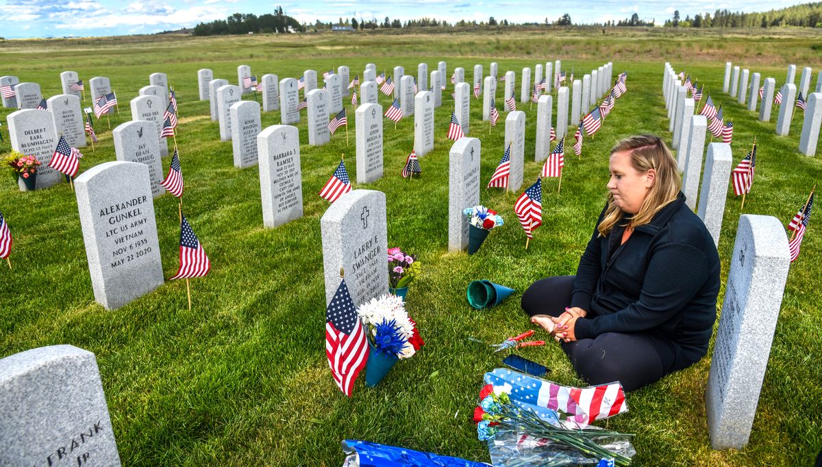 Kelsey Lopez visits the grave of her grandfather, U.S.A.F. veteran Larry Swanger, Friday, May 28, 2021, at the Washington State Veterans Cemetery in Medical Lake. "I want to just come and be in the presence of my grandpa," says Lopez. She visited 12 grave sites on the day and is keeping the tradition started by her grandmother Karen Swanger.  (DAN PELLE/THE SPOKESMAN-REVIEW)
