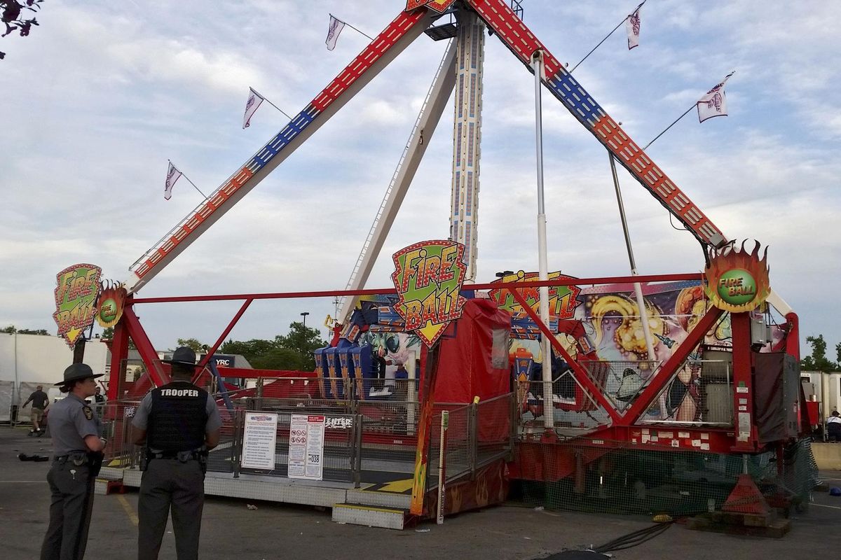 Authorities stand near the Fire Ball amusement ride after the ride malfunctioned injuring several at the Ohio State Fair, Wednesday, July 26, 2017, in Columbus, Ohio. Some of the victims were thrown from the ride when it malfunctioned Wednesday night, said Columbus Battalion Chief Steve Martin. (Jim Woods / Columbus Dispatch)