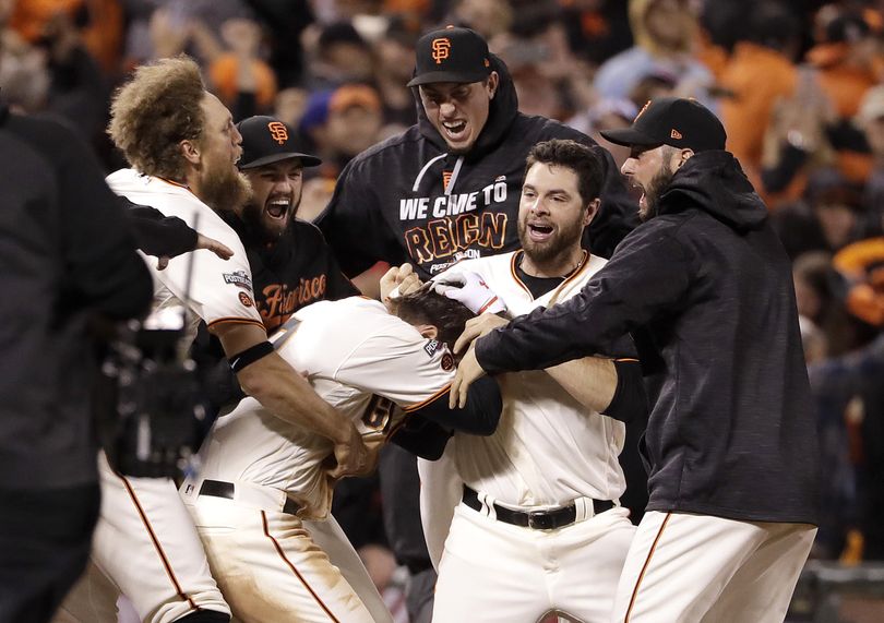 San Francisco’s' Joe Panik, center bottom, is congratulated by teammates after hitting a double to score Brandon Crawford with the winning run in the bottom of the 13th, defeating the Cubs 6-5. (Marcio Jose Sanchez / Associated Press)