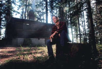 
Author John Maclean, son of acclaimed novelist Norman Maclean, sits near a cabin in the woods at Seeley Lake, Mont., in this file photo. Maclean's lastest book about fatal fires is 