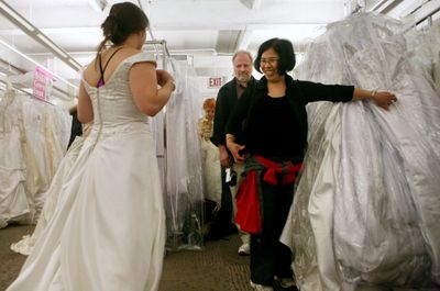 Dr. Mary Fitzgerald, from New Brunswick, N.J., shows a bridal gown to her parents Pat, center, and Sue Fitzgerald, from Utica, N.Y., during the 