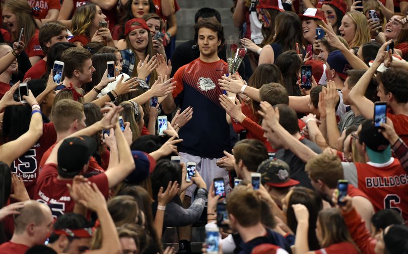 Senior, Gonzaga guard Kevin Pangos (4) makes his way through the Kennel Club student section after being introduced during Senior Night before the game with BYU, Sat., Feb. 28, 2015, in the McCarthey Athletic Center. (Colin Mulvany / The Spokesman-Review)