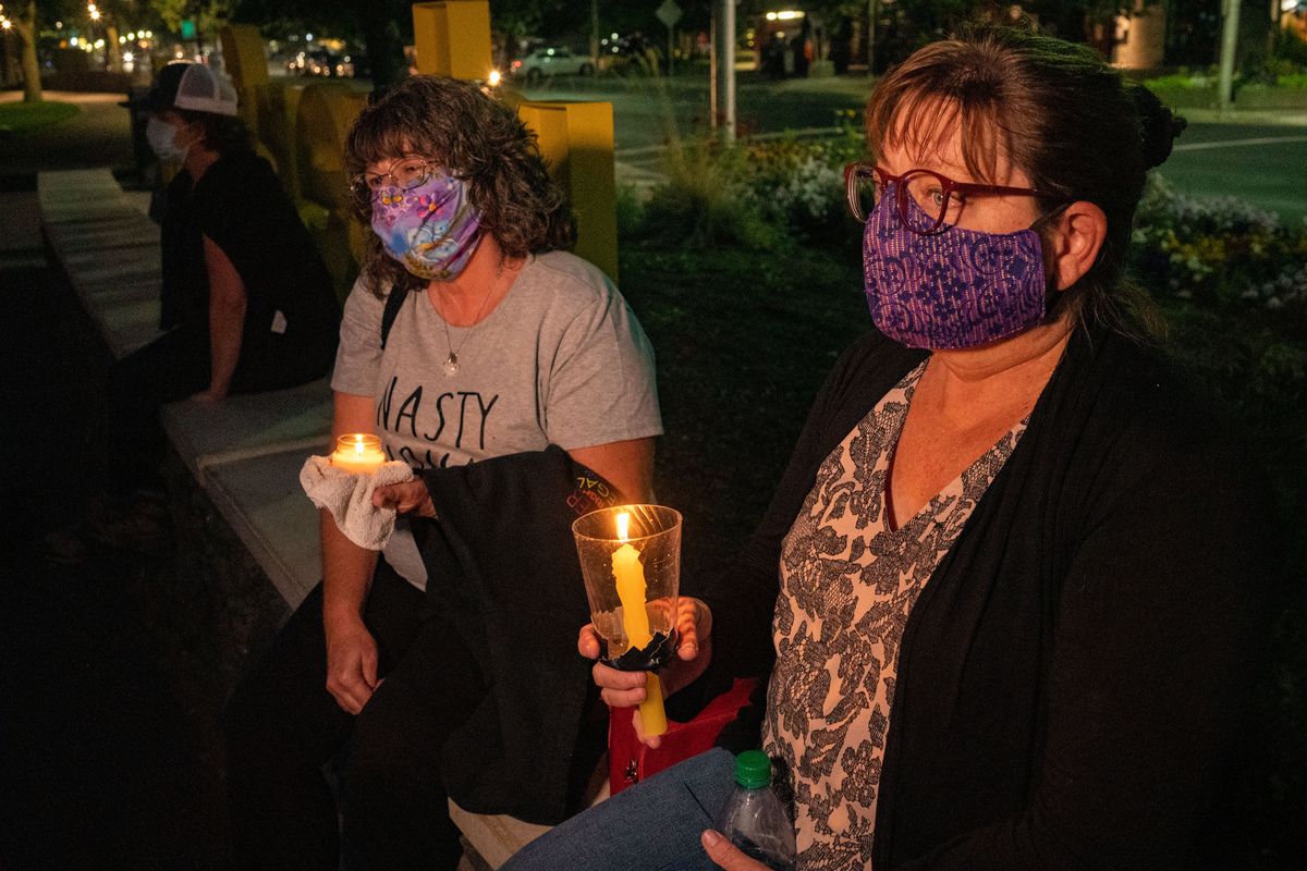Ann Forwood, left, and Wendy Christy hold a silent vigil after a Kentucky grand jury brought no charges against Louisville police for Breonna Taylor’s death. About two dozen protesters marched through Riverfront Park on Wednesday. “We’re just two old ladies fighting for justice,” Forwood said.  (COLIN MULVANY)