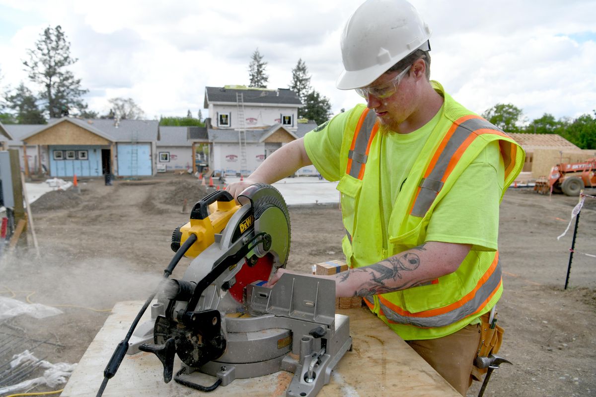 Wolfgang Ford, 22, uses a saw to trim shims that he will place around windows in the cottages being built by Transitions, a housing program for women and families in north Spokane Thursday, May 10, 2018. Ford is getting a temporary work at the job site through YouthBuild, a nonprofit that gives at-risk youth a chance to learn construction skills and get job experience. (Jesse Tinsley / The Spokesman-Review)