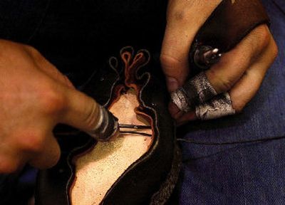
Quick and nimble fingers thread string around and through the base sole of the shoe.
 (The Spokesman-Review)