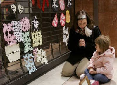 
Nadine Cooper  and her 3-year-old daughter Emma pay their respects Saturday to the victims of the Von Maur department store shooting at the Westroads Mall in Omaha, Neb.Associated Press
 (Associated Press / The Spokesman-Review)