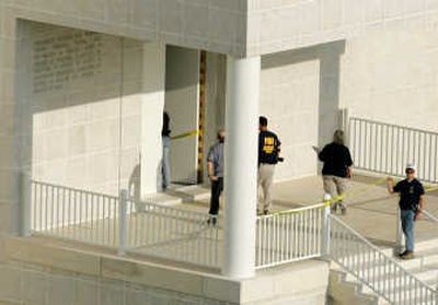 An FBI agent and another law enforcement official enter the temple at the compound Tuesday.
(The Spokesman-Review)
