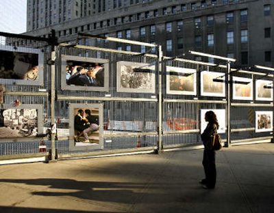 
A commuter stops by a fence at the World Trade Center site in New York on Sunday to look at photographs of the 9/11 terrorist attacks.
 (Associated Press / The Spokesman-Review)