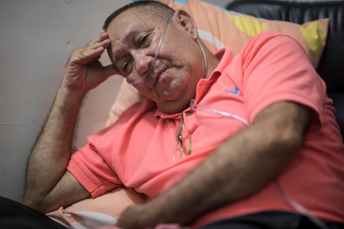 Victor Escobar sits at his home during an interview in Cali, Colombia, Thursday, Jan. 6, 2022. Escobar, who suffers chronic obstructive pulmonary disease, oxygen dependence, lack of muscle control and secondary effects from a stroke is scheduled on the evening of Jan. 7 to become the first person to receive euthanasia legally, without being a terminally ill patient. Euthanasia for terminally ill patients is legal in Colombia.  (Ivan Valencia)