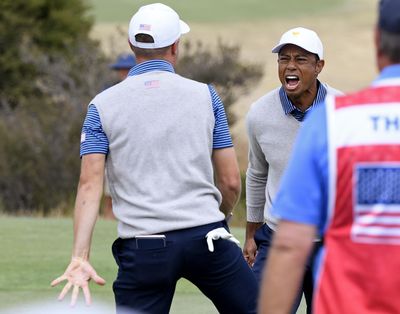 U.S. team player Justin Thomas, left, celebrates with his playing partner and captain, Tiger Woods, on the 18th green in their foursomes match during the President's Cup golf tournament at Royal Melbourne Golf Club in Melbourne, Friday, Dec. 13, 2019. (Andy Brownbill / AP)