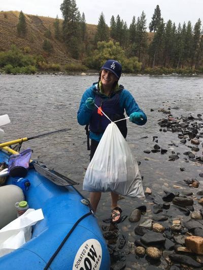 A volunteer works with rafters to collect trash on Sept. 17, 2016, during the annual Spokane River Clean-up and Upriver Scrub. (Spokane River Forum)