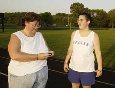 
Susan Hedrick checks her pedometer after walking with her daughter, Niki Hedrick, around the track at Brown County High School in Nashville, Ind.
 (Associated Press / The Spokesman-Review)