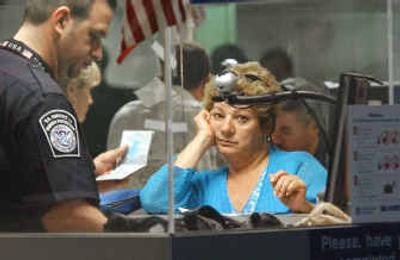 
A woman traveling from South America watches as her data comes up on a computer screen after she was fingerprinted and photographed as she arrived at Miami International Airport. U.S. travel executives say President Bush's war on terror is unintentionally scaring off foreign tourists.
 (Associated Press / The Spokesman-Review)