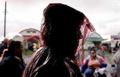 
Kristine Mulligan of Coeur d'Alene braves the wet weather Wednesday while waiting in line for a snack on opening day of the North Idaho Fair and Rodeo at the Kootenai County Fairgrounds. 
 (Kathy Plonka / The Spokesman-Review)