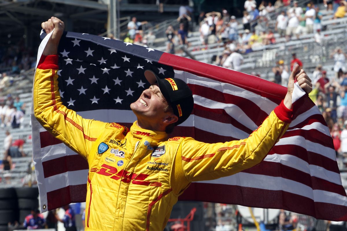 Ryan Hunter-Reay waves the flag after becoming the first American to win the Indy 500 in eight years in the second-closest finish in the history of the race. (Associated Press)