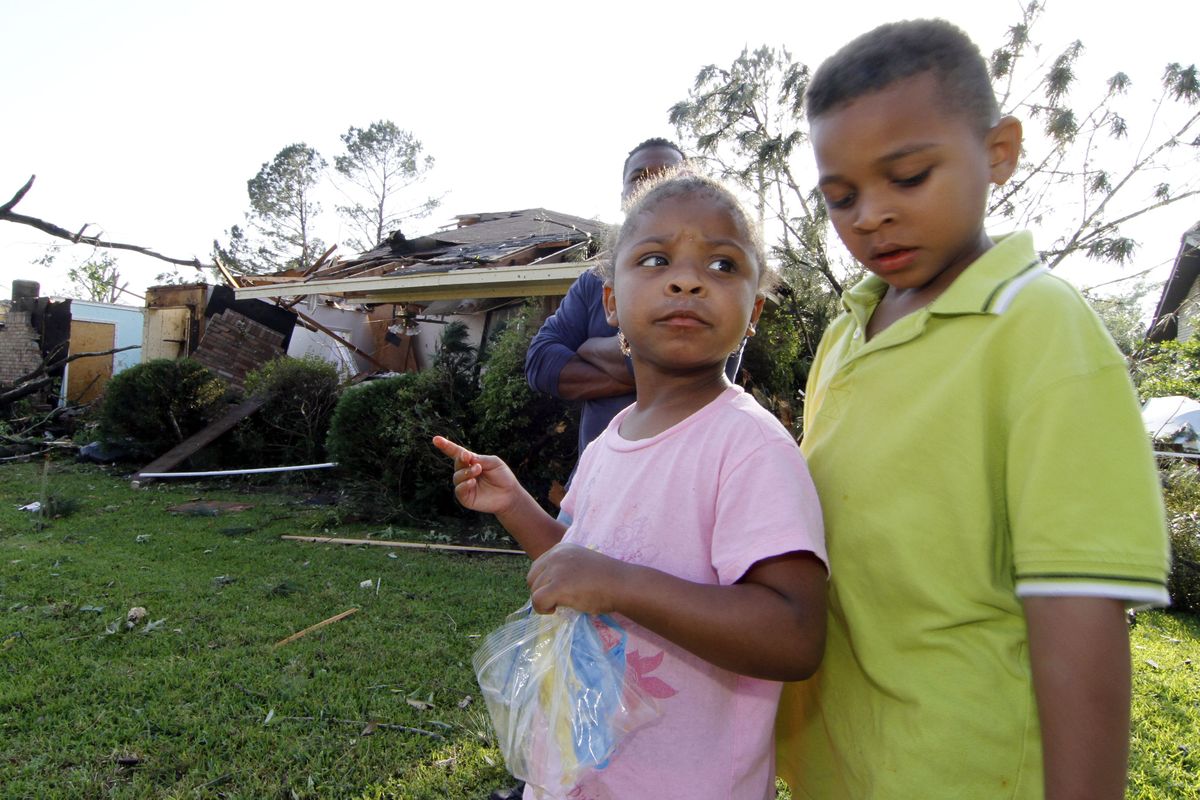 Queen Russell, 3, looks at her big brother Caleb Russell, 6, following a tornado that hit Clinton, Miss., Friday. (Associated Press)