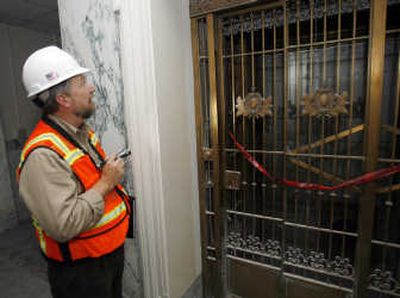 
John Emery, project manager at the Idaho Statehouse renovation, looks Tuesday at an old brass elevator car, hidden behind a bookcase in a closed-off elevator shaft. The recently uncovered elevator is believed to be more than a century old, and no one is sure how long it had been hidden. Idaho Statesman
 (Darin Oswald Idaho Statesman / The Spokesman-Review)