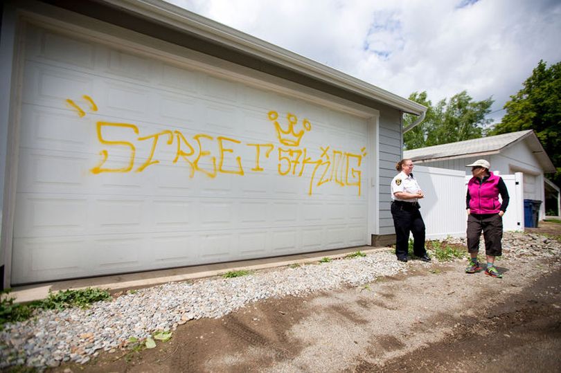 Coeur d'Alene report taker Candy Rohrscheib talks to Suzanne Marshall on Wednesday about graffiti vandalism reading 