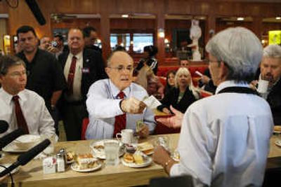 
Republican presidential hopeful and former New York Mayor Rudy Giuliani pays his breakfast tab during a visit to Wolfie Cohen's Rascal House Restaurant in Sunny Isles Beach, Fla., on Tuesday. Associated Press
 (Associated Press / The Spokesman-Review)