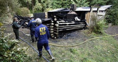 
Investigators on Tuesday look over the remains of the replica of Fort Clatsop. 
 (Associated Press / The Spokesman-Review)