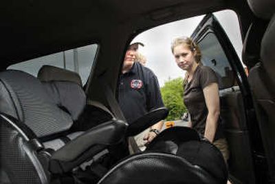 
Sheri Smith gets help Saturday from Tim Steiner in checking the child safety seat she uses for her son Kaden. 
 (CHRISTOPHER ANDERSON / The Spokesman-Review)