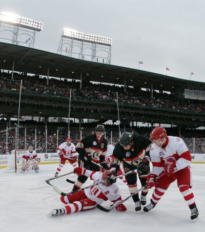 Detriot and Chicago  players battle for the puck during the third period of the NHL Winter Classic on Thursday at Wrigley Field.  AP photo/Detroit Free Press (AP photo/Detroit Free Press / The Spokesman-Review)