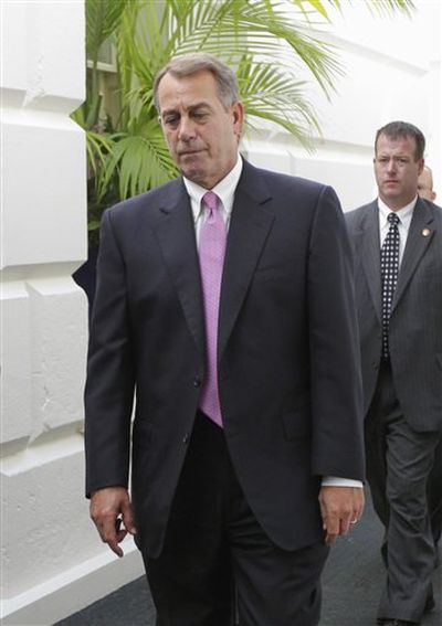 House Speaker John Boehner of Ohio walks through a basement corridor in the Capitol in Washington on Wednesday, after an afternoon caucus with House Republicans seeking an agreement on legislation to raise the nation's debt limit. (Associated Press)