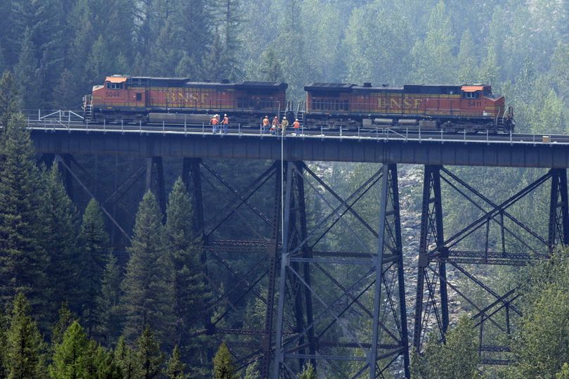 BNSF Railway crews install sprinklers on a trestle as the Sheep Fire burns near Essex, Mont, on Thursday, Aug. 20, 2015. Crews were working Thursday to prevent the wildfire from spreading to the small Montana community of Essex as authorities closed a major transportation corridor on Glacier National Park's southern boundary. Essex was evacuated on Aug. 27. (Greg Lindstrom / Flathead Beacon via AP)