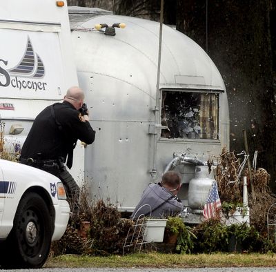  Above left: A Clark County deputy, left, and German Township Patrolman Jeremy Blum open fire on a trailer Saturday near Enon, Ohio.  Above right: Blum falls back after being wounded.  He was  taken to Miami Valley Hospital, where he was  in stable condition, according to German Township Police Chief William Dickerson. 