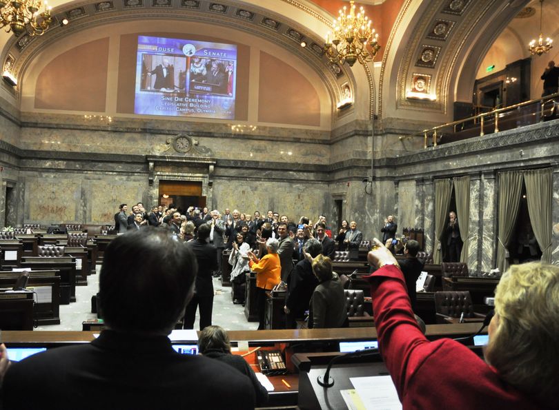 OLYMPIA -- From behind the president's rostrum, Gov. Chris Gregoire points at the twin screens showing leaders of the House and Senate declaring the end of the special session.  (Jim Camden/The Spokesman-Review)