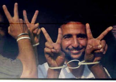 
A Palestinian prisoner flashes the victory sign as he waits on a bus before leaving an Israeli prison early Thursday.
 (Associated Press / The Spokesman-Review)