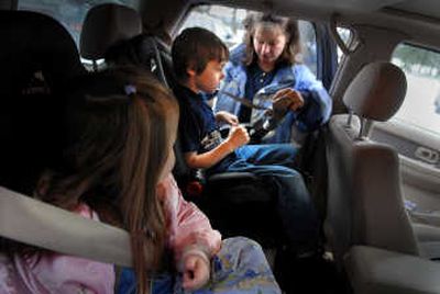 
Kristine Horrocks secures Grant Gentry, 7, into a booster seat Nov.  30 as Holly Horrocks watches in Coeur d'Alene. 
 (Brian Plonka / The Spokesman-Review)