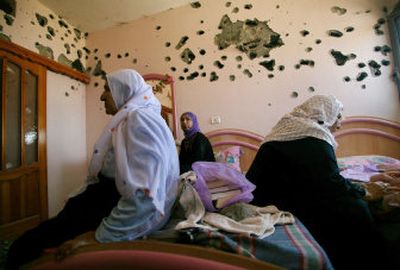 
Palestinians from the Al Aljuwi family sit in their house next to a wall riddled by Israeli army gunfire after the army pulled back from the area in Beit Lahiya, northern Gaza, on Saturday.
 (Associated Press / The Spokesman-Review)