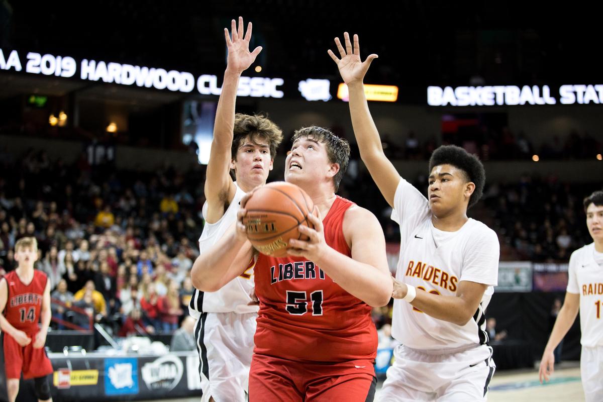 Jon Denny (51) of Liberty goes up to the hoop under pressure from Sam Wapato and Tyler Jordan of Lake Roosevelt in a first round game of the state 2B tournament on Wednesday, Feb. 27, 2019, at the Spokane Arena. The Lake Roosevelt Raiders beat the Liberty (Spangle) Lancers 41-37. (Libby Kamrowski / The Spokesman-Review)